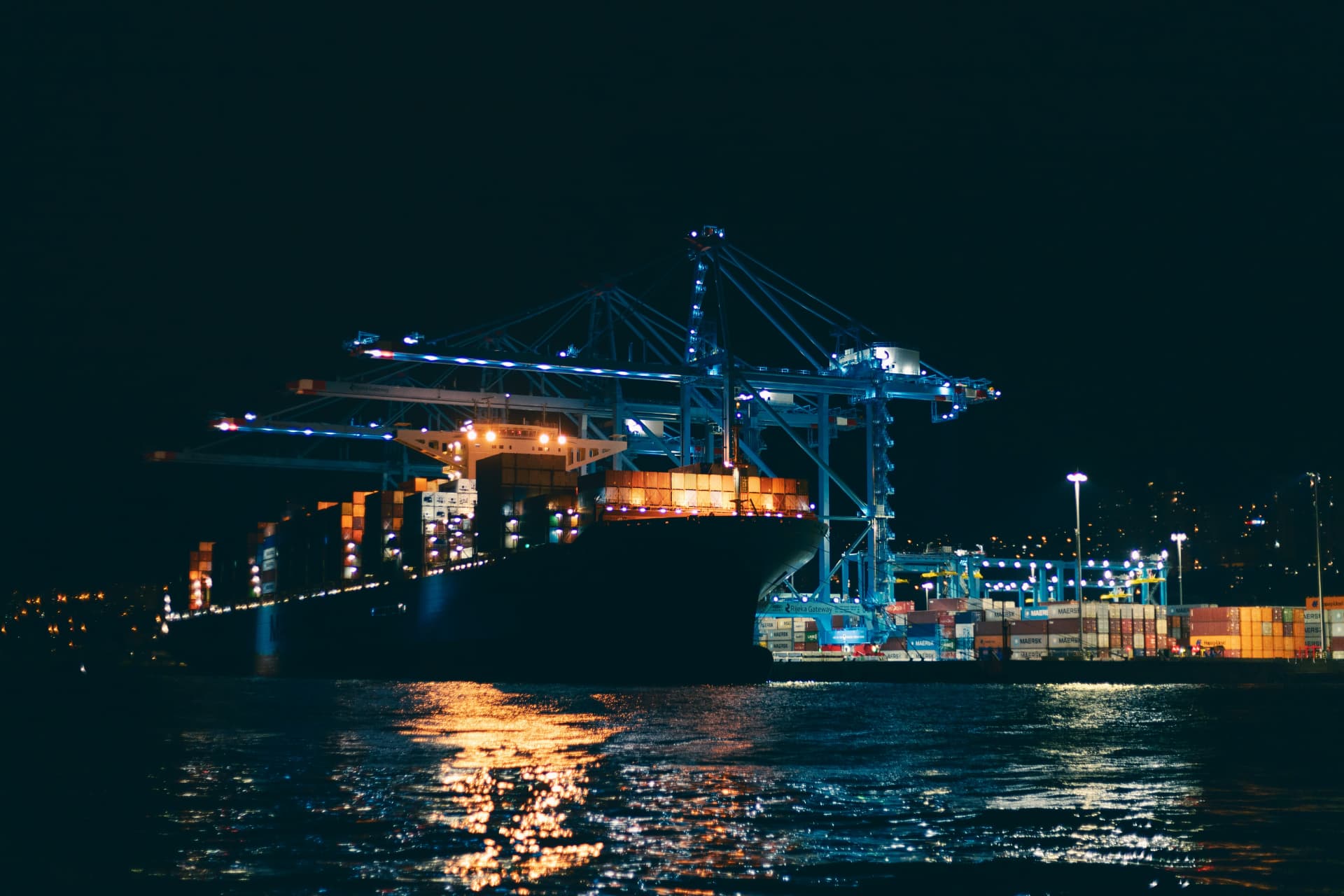 Puerto de contenedores de noche con grúas iluminadas